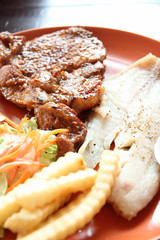 grilled pork steak with french fries and toast.