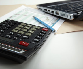 Calculator, pen, folder with documents, laptop