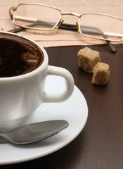 Cup of coffee near press.