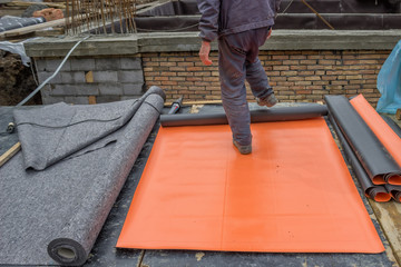 Worker preparing insulation material for basement wall