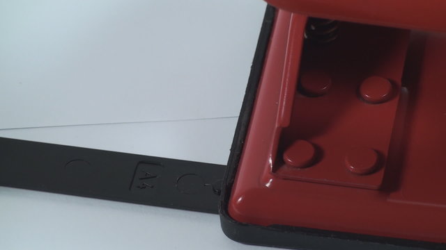 Inserting Paper Measurement In Paper Puncher Isolated