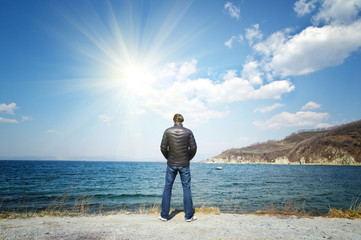 man stands on a background of sea and sun