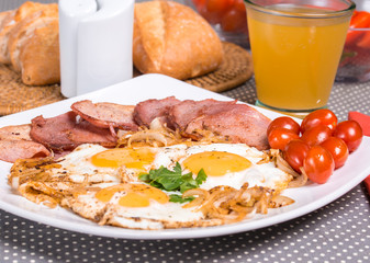 Breakfast with fried eggs beacon onion and fresh tomatoes