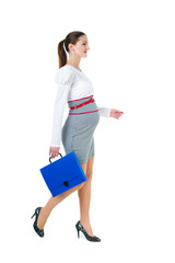 Portrait of walking pregnant businesswoman with document case