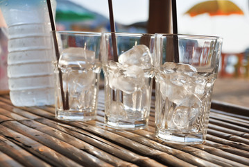 Glass of ice on the table at sunset summer