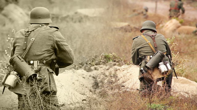 Soldiers shooting with a rifle in trench . WWII old film movie