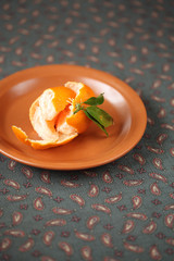 Tangerine on a brown plate