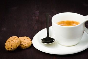 cup of espresso coffee and biscuit near spoon