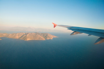 Fototapeta na wymiar Widok z samolotu nad morzem, w górach, skrzydło