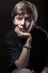portrait of a male teenager with black background