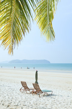 Lounges under an umbrella on sandy beach 