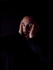 Low key image of a bearded man with shocked expression