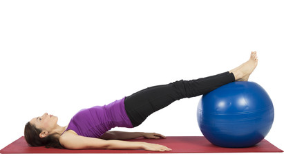 Young fitness woman working her abs with pilates ball
