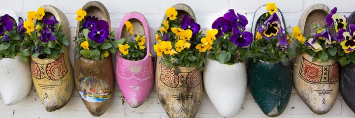 Fototapeten Dutch wooden clogs with flowers © HildaWeges