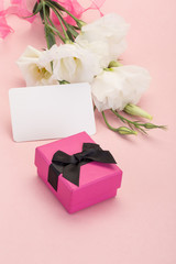 gift and flowers on pink