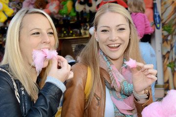 Frauen essen Zuckerwatter auf Jahrmarkt