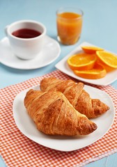 Croissants, tea and orange juice for breakfast
