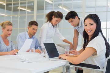 Casual businesswoman smiling at camera during meeting