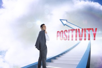 Positivity against red staircase arrow pointing up against sky