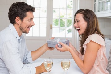 Man giving happy woman a gift box at home