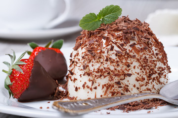 Strawberry in chocolate and dessert panna cotta on a plate