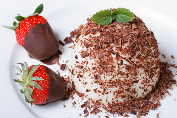 panna cotta dessert and strawberries in chocolate top view