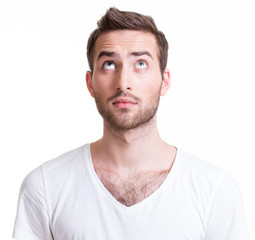 Fototapeta premium Portrait of serious handsome young man looking up.