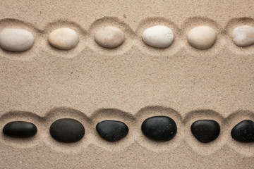 Fototapeta na wymiar White and black stones lying in the sand