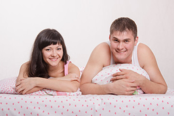 Happy young man and woman in bed