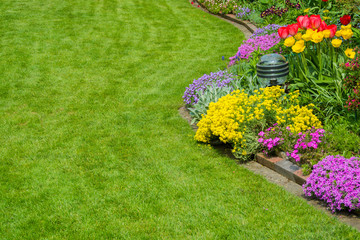 schöner Rasen mit Blumenbeet