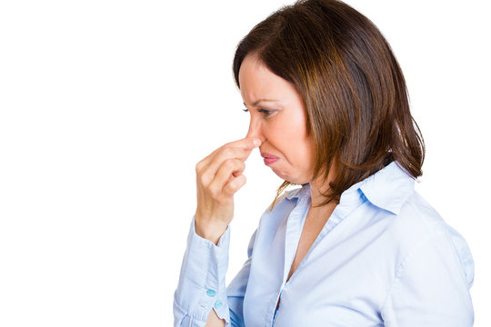 Woman pinches her nose, something stinks, unpleasant odor