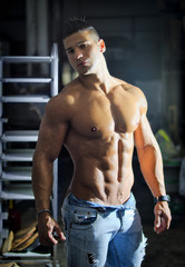 Fototapeta na wymiar Muscular young latino man shirtless in jeans indoors
