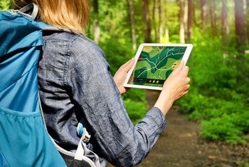 Hiking Woman using Tablet PC with Map outdoors
