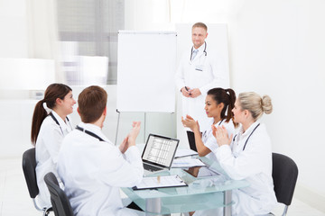 Doctors Clapping For Colleague After Presentation