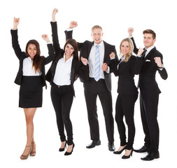 Successful Welldressed Businesspeople With Arms Raised