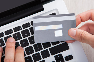 Businessman With Credit Card Shopping Online At Desk