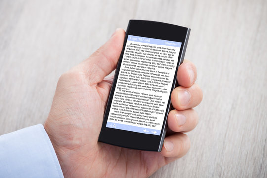 Businessman's Hand Displaying eBook On Smartphone