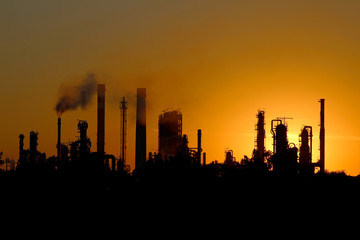 Fototapeta na wymiar sylwetka ibig fabryki rafinerii ropy naftowej o zachodzie słońca