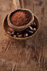 cocoa beans and grated dark chocolate in old texured spoons bowl