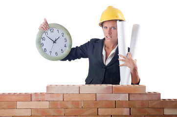 Woman construction worker with clock on white