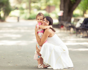Fototapeta na wymiar Beautiful portrait of little daughter embracing her mommy.