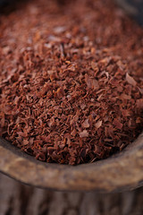 fine grated chocolate in old wooden spoon