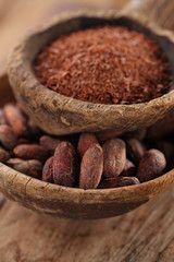 cocoa beans and grated dark chocolate in old texured spoons bowl