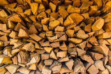 Background of dry chopped firewood logs in a pile