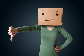 Young girl gesturing with a cardboard box on her head with strai