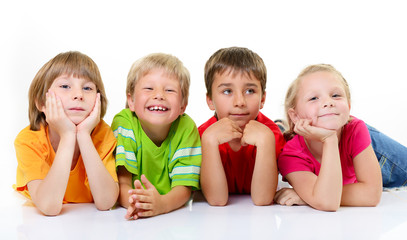 cute children in colored t-shirts lying and smiling, over white