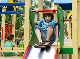 Fototapeta na wymiar children playing on playground in summer outdoor park