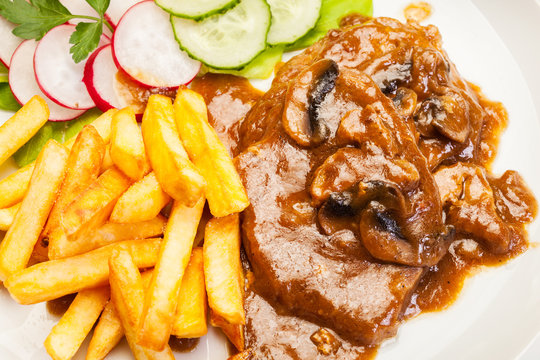 Pork chop with sauce, mushrooms and chips