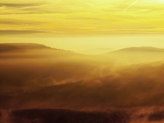 Autumn sunrise in a beautiful mountain of Bohemia. Hills in fog