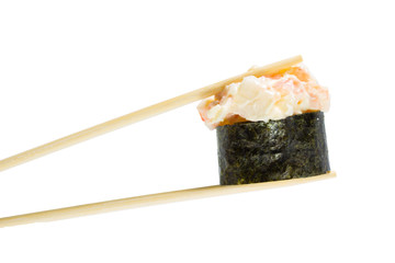 Isolated sushi gunkan in chopsticks. Macro.